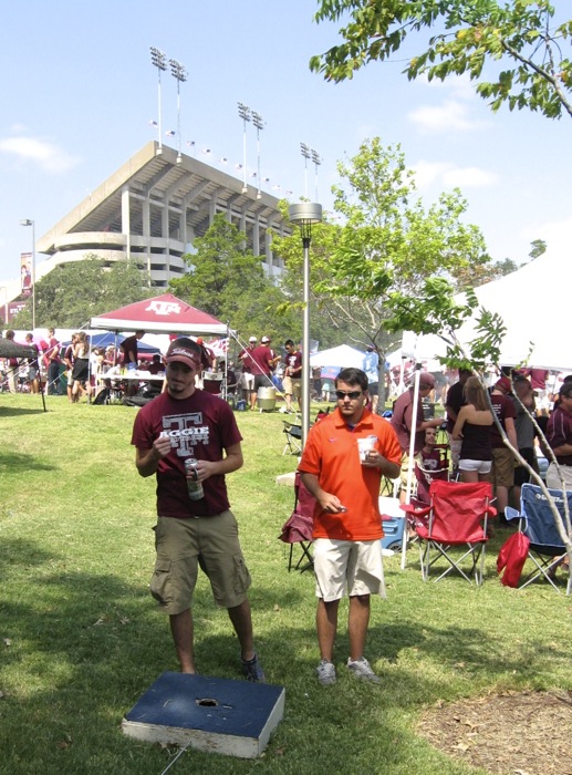 Cornhole competition between Gator Ryan and Aggie fan photo by Kathy Miller