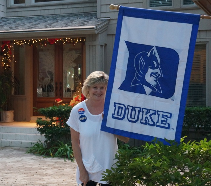 Kathy & Duke flag wearing her Duke and Beat the Noles buttons photo by Kathy Miller