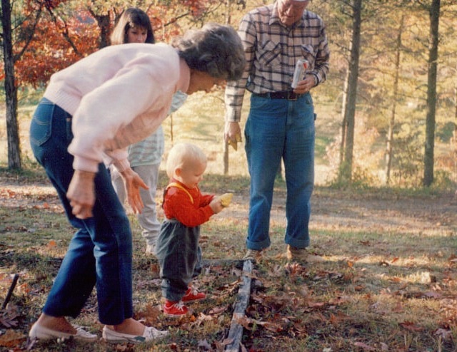 Grandma at the farm teaching James early how to play corn hole photo by Kathy Miller