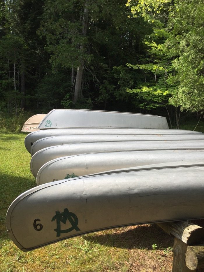 canoes lined up in a row at Camp Winape photo by Kathy Miller