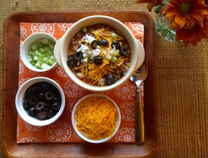 Sante Fe Soup with garnishes of cheddar cheese, black olives, green scallions photo by Kathy Miller