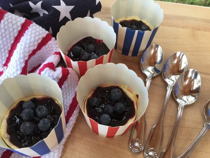 Mini Blueberry Cheesecake closeup in patriotic red and blue striped baking cups photo by Kathy Miller