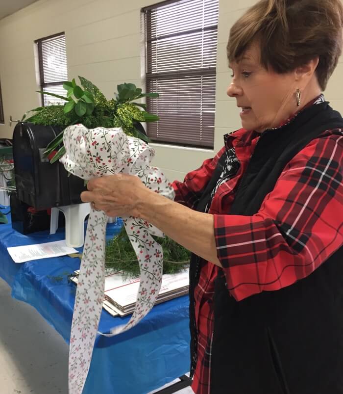 Sylvie shows how to make bows for mailbox decoration photo by Kathy Miller