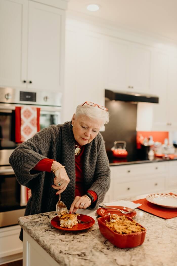 Lib Schuler dishing up her Meat and Cheese Casserole photo by Page Tehan