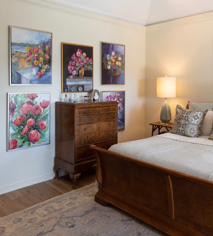 Main bedroom with Kathy Miller original flower paintings photo by Lynn Tennille