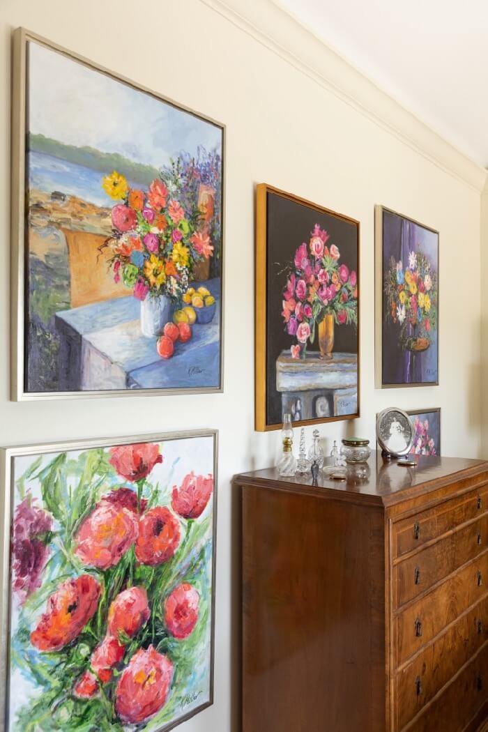 Kathy's flower paintings with antique chest and perfume bottle collection