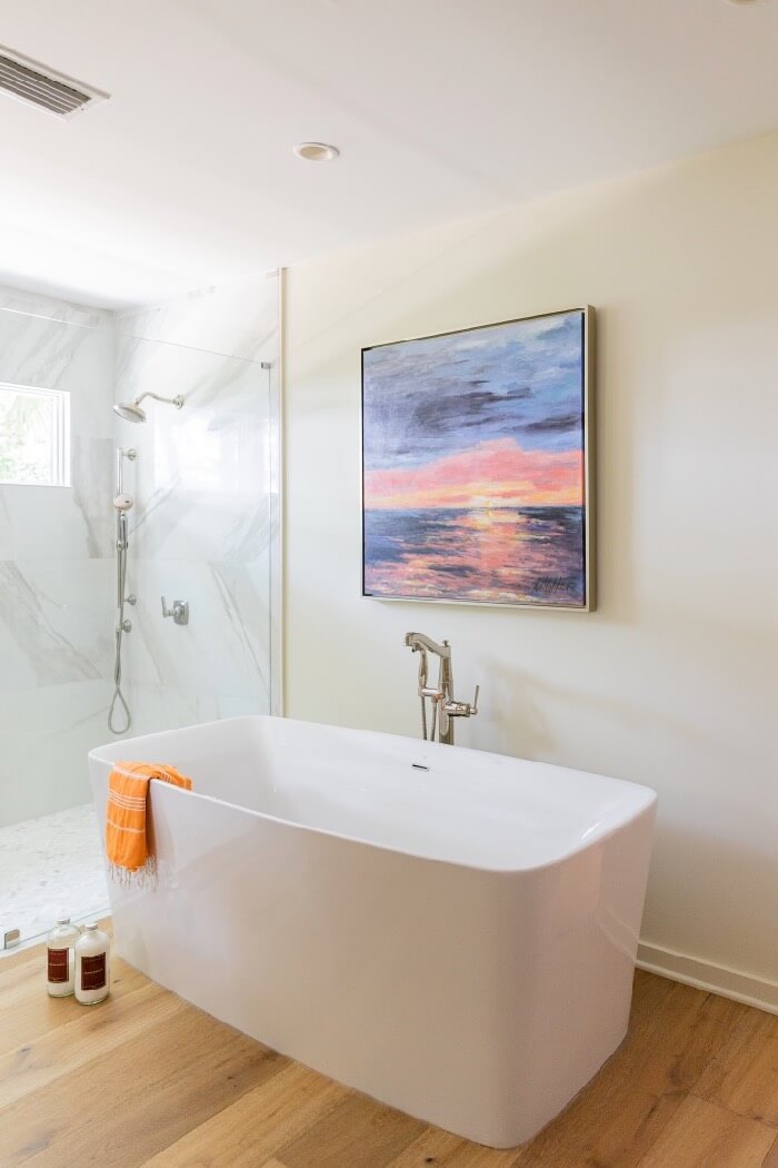 Soaking tub and large walk in shower with window for natural light painting by Kathy Miller Amelia Sunrise photo by Lynn Tennille