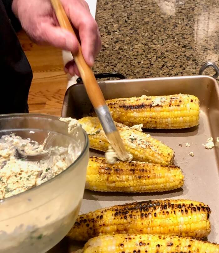 Lathering the Grilled Corn with Cotija cheese mixture 
